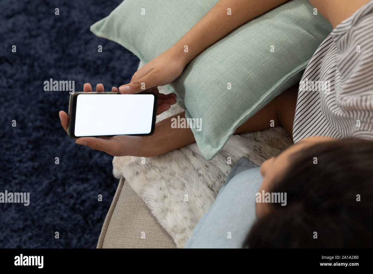 Giovane donna di casa utilizzando uno smartphone Foto Stock