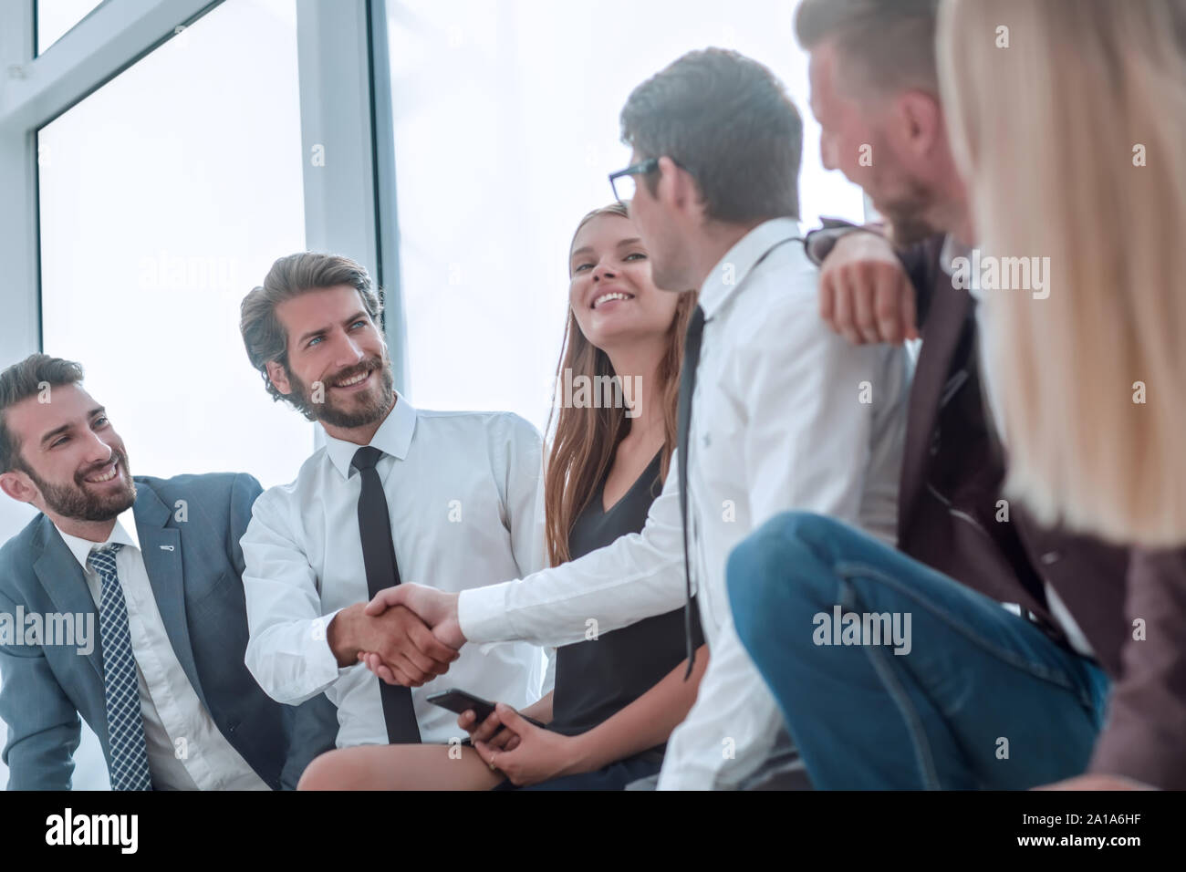 Colleghi di lavoro che stringono le mani nella lobby del centro business Foto Stock