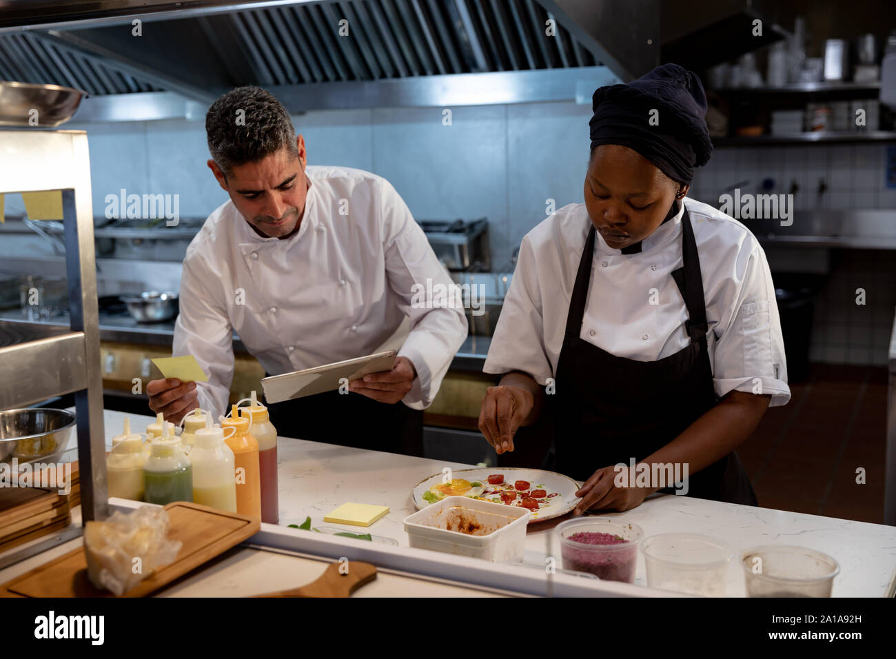Il personale del ristorante prepara gli ordini in cucina Foto Stock