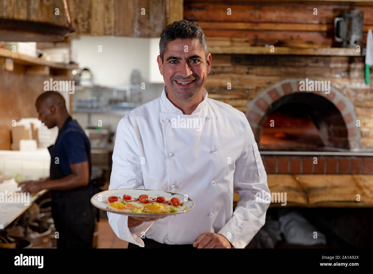 Lo Chef tenendo un piatto preparato nel ristorante cucina Foto Stock