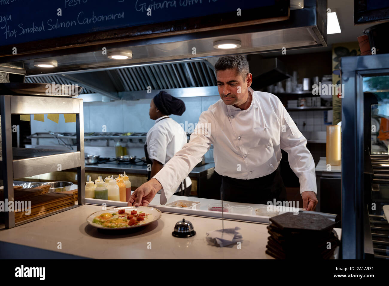 Il personale del ristorante prepara gli ordini in cucina Foto Stock
