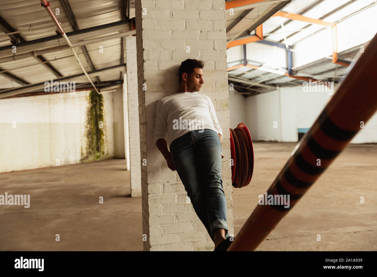 Ballerino maschio in un magazzino vuoto Foto Stock