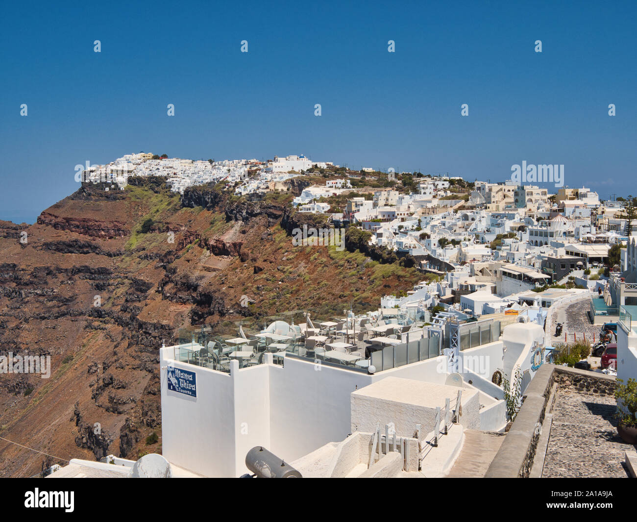 Vecchia città di montagna di Oia con case bianche e strade strette sul isola di Santorini in Grecia sotto il cielo blu Foto Stock