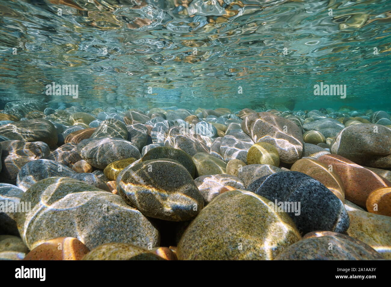 Ciottoli subacquea in pietra al di sotto della superficie dell'acqua vicino alla riva del mare, scenario naturale, Mediterraneo, Cote d'Azur, in Francia Foto Stock