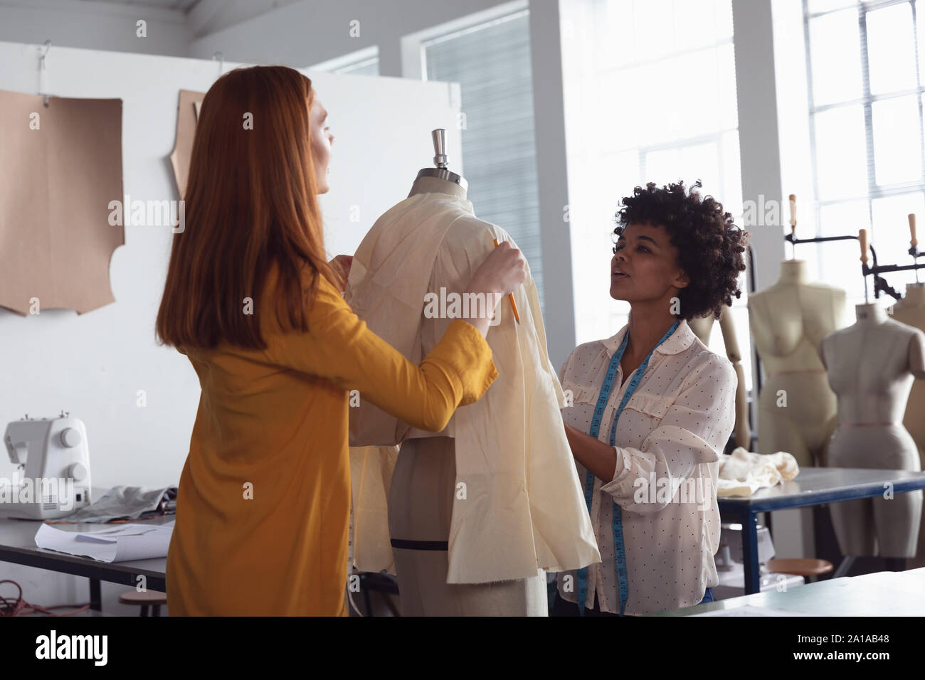 Studenti di sesso femminile lavorando su un indumento in un collegio di moda Foto Stock