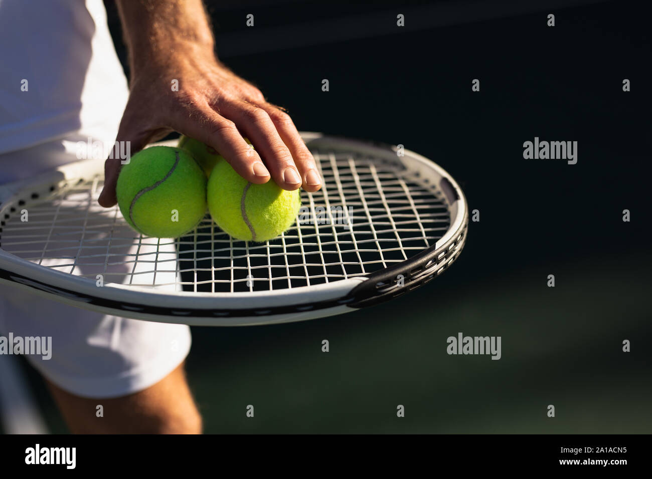 L'uomo gioca a tennis in una giornata di sole Foto Stock