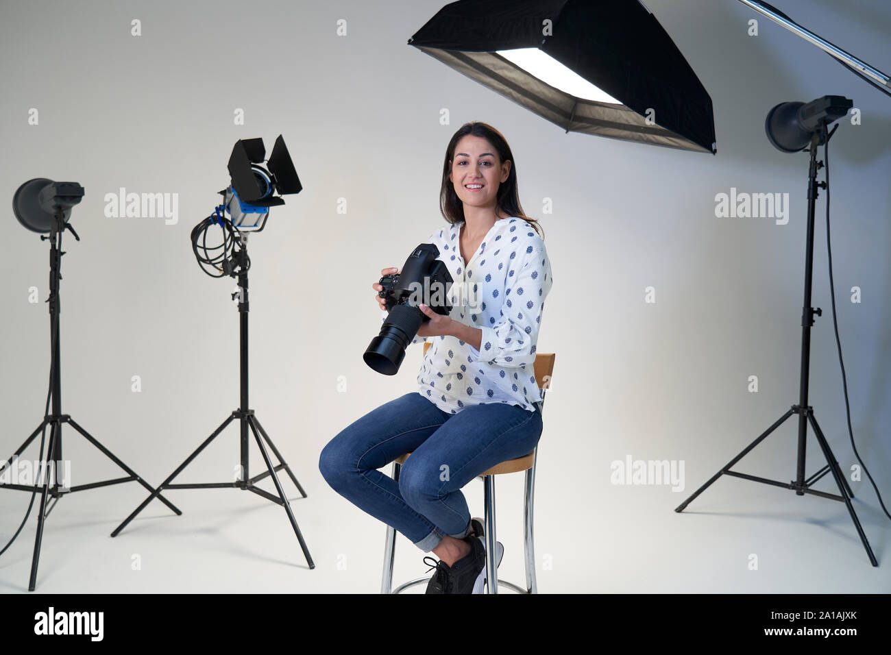 Ritratto di donna fotografo in studio per scattare foto con la fotocamera e apparecchiature di illuminazione Foto Stock