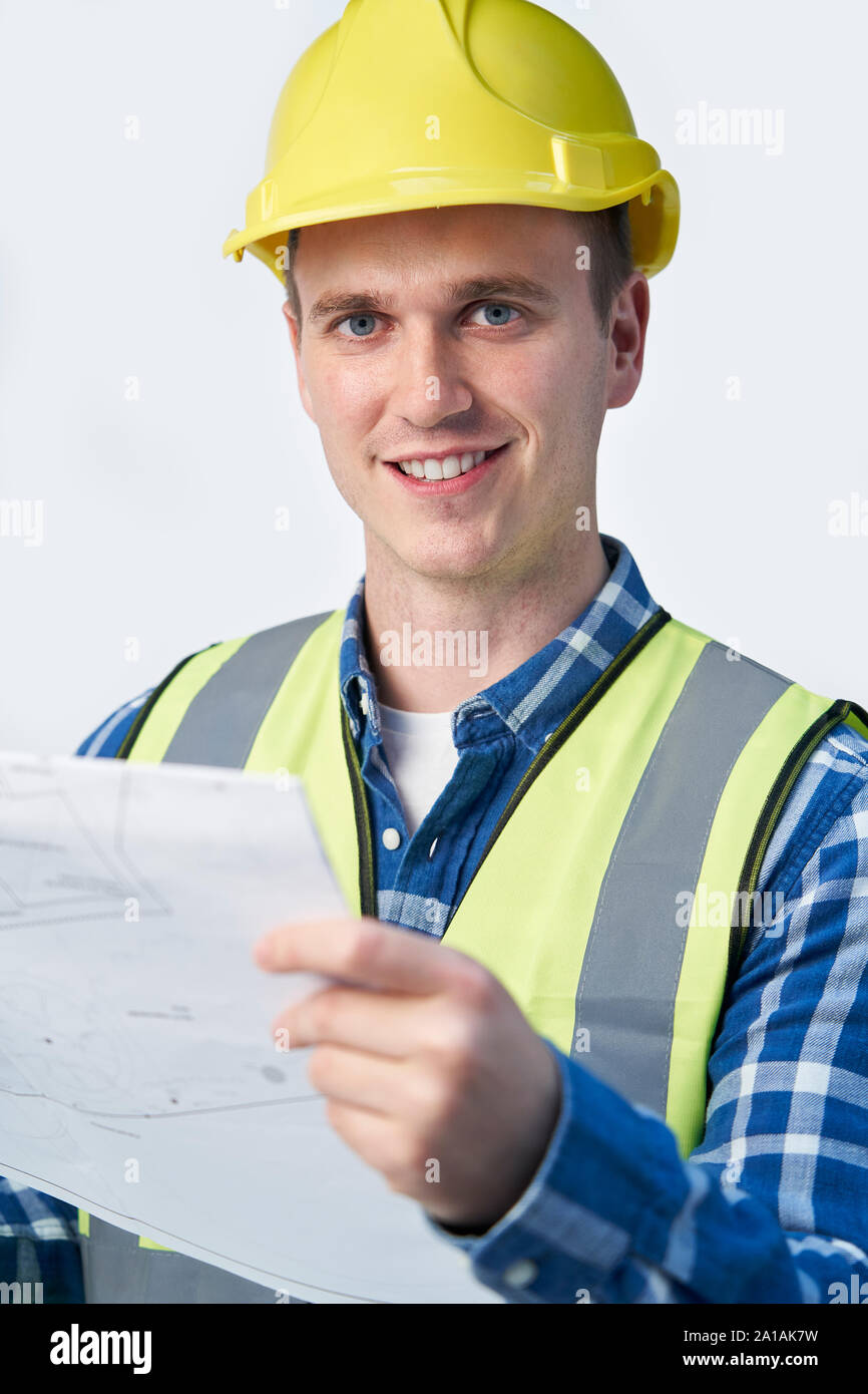 Ritratto in studio di architetto Builder Guardando i piani contro uno sfondo bianco Foto Stock