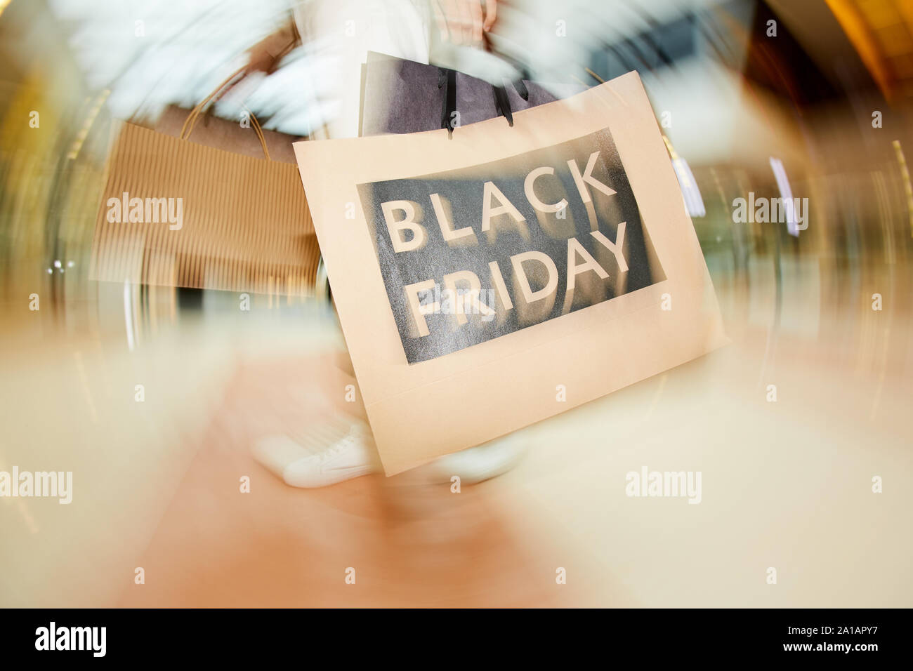 Moto offuscata della donna in piedi con le borse della spesa dopo il black friday in the mall Foto Stock