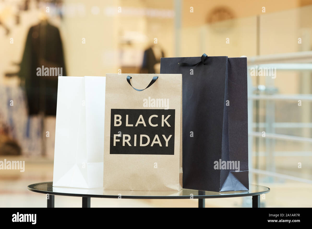 Immagine del bianco e nero delle borse per lo shopping in piedi sulla tavola dopo il venerdì nero nel centro commerciale per lo shopping Foto Stock