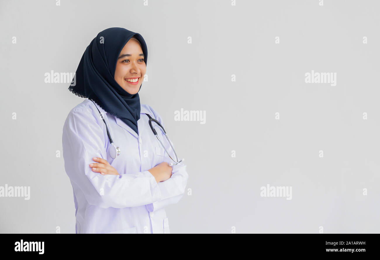 Giovani Musulmani arabi intern medico donne sorriso sulle labbra per isolare lo sfondo bianco concetto per l'Islam persone che lavorano in ospedale medico health care, infermiera moderno Foto Stock