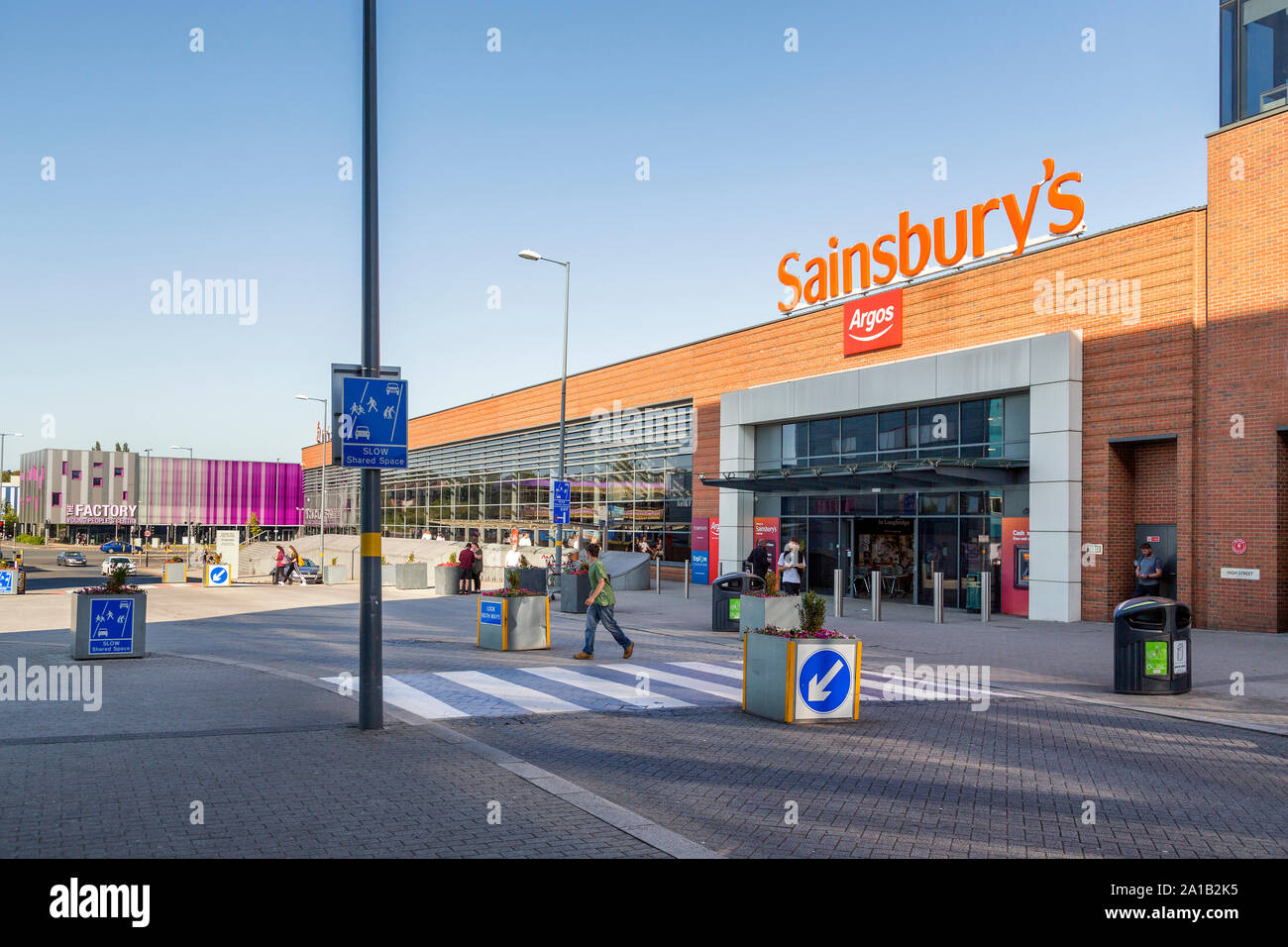 Centro di Longbridge dominato dal superstore di Sainsbury. Il Centro per i giovani della fabbrica è visibile alla fine della strada. Foto Stock