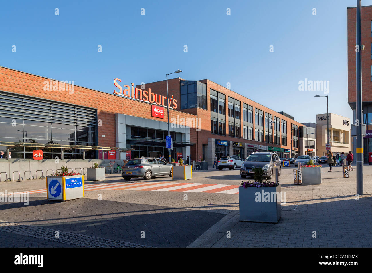 Longbridge centro città dominata da Sainsbury Superstore del. Nella parte anteriore del negozio un cartello stradale consiglia di uno spazio condiviso per il traffico e i pedoni. Foto Stock