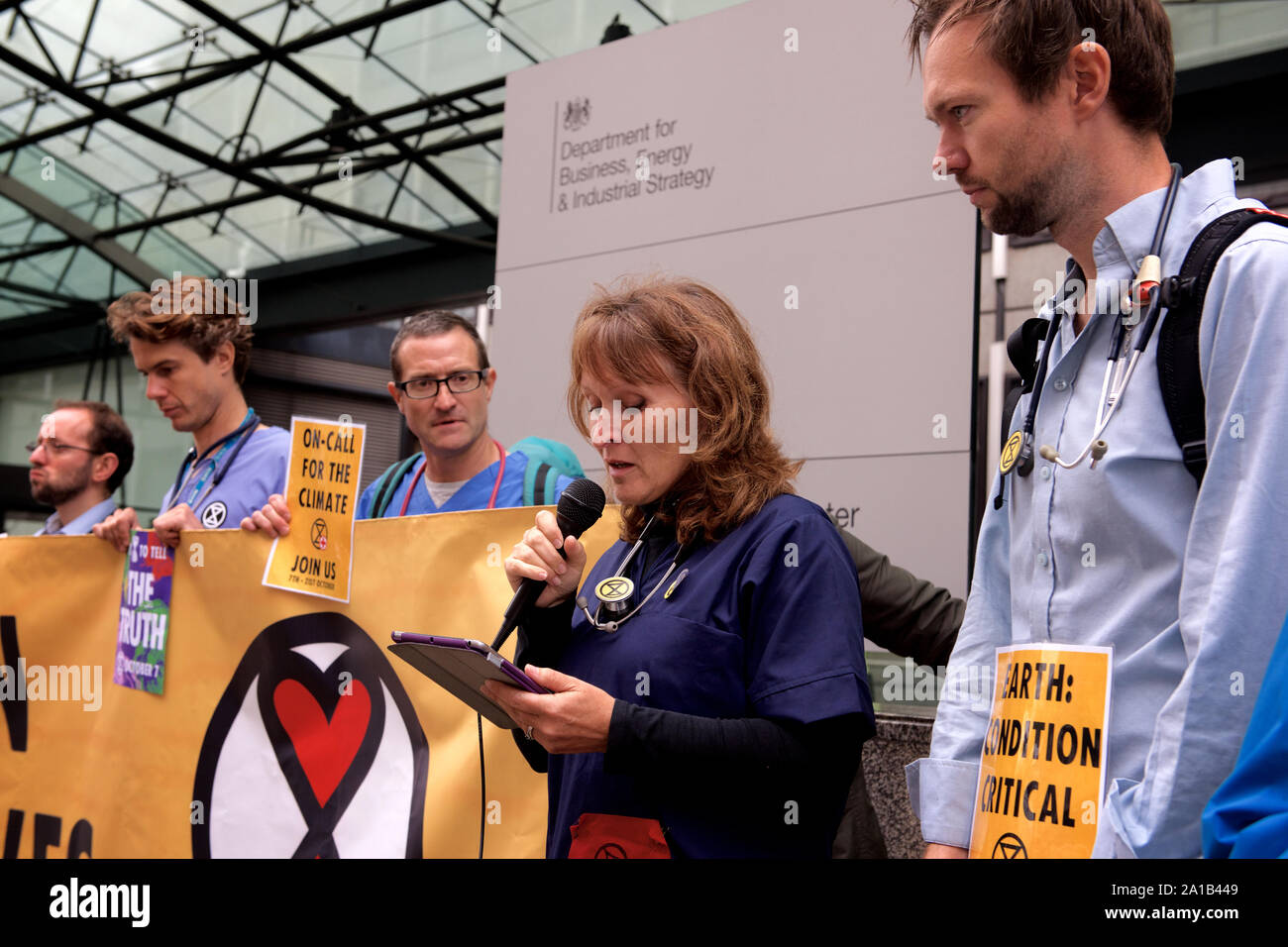 Londra, Regno Unito. 25 Settembre, 2019. I medici a protestare con la ribellione di estinzione stessi incollato ad un palazzo del governo per protestare contro la minaccia del cambiamento climatico sulla salute a livello mondiale. Questo gruppo di medici e professionisti della sanità sta chiamando per azione per l' imminente crisi di salute pubblica derivanti dal clima e crollo ecologico". Credit Gareth Morris/Alamy Live News Foto Stock