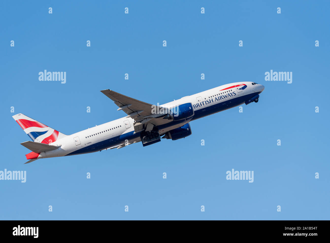 British Airways Boeing 777 aereo di linea G-YMMA decolla dall'aeroporto di Londra Heathrow, Londra, Regno Unito in cielo blu Foto Stock