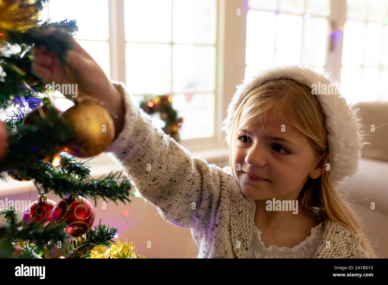 Ragazza decorare albero a tempo di Natale Foto Stock