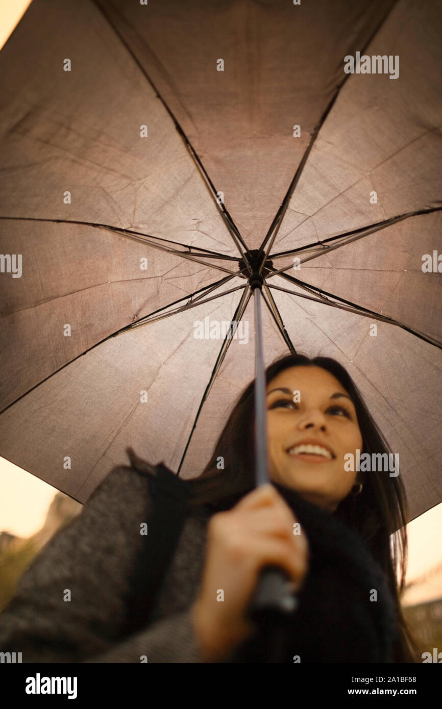 Sorridente ragazza camminare a lavorare in un giorno di pioggia. Foto Stock