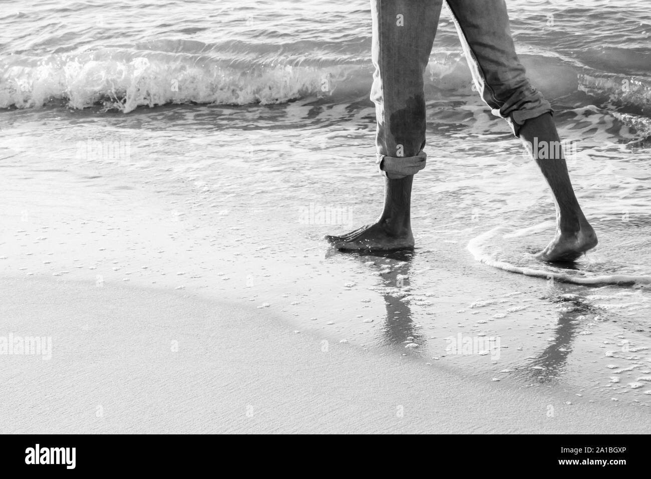 Uomo che cammina su una spiaggia Foto Stock