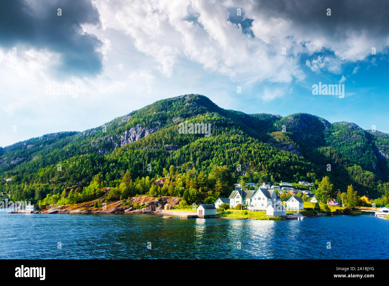 Tipico paesaggio norvegese con un piccolo villaggio sulla costa del fiordo Foto Stock