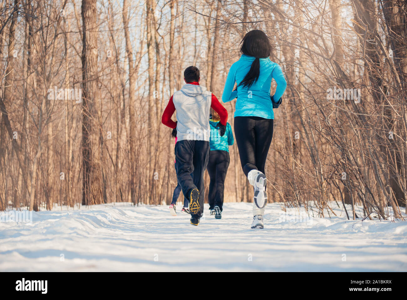 Gruppo di amici gustando il jogging sulla neve in inverno Foto Stock