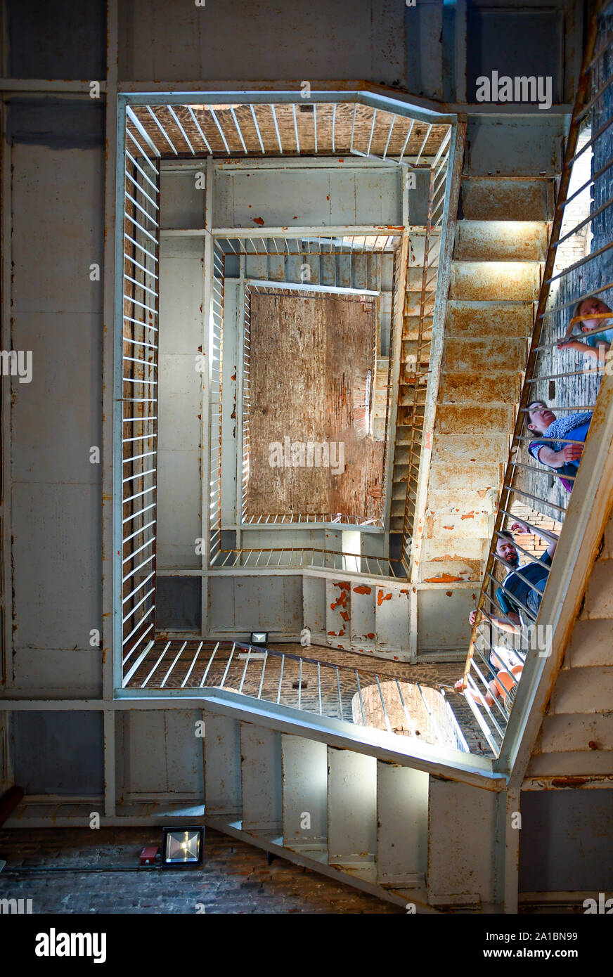Vista dal basso della parte interna della torre Guinigi nel centro storico di Lucca con i turisti che scendono le scale ripide, Toscana, Italia Foto Stock