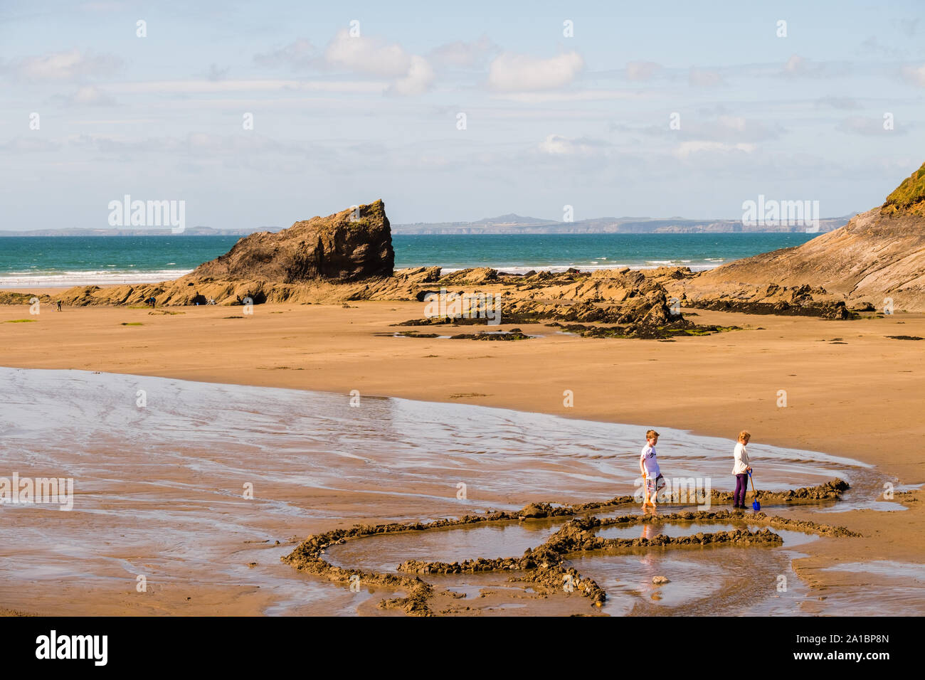Bambini godendo il sole su vasta Oasi Beach sulla costa di St sposa's Bay, Pembrokeshire National Park, South West Wales UK Foto Stock