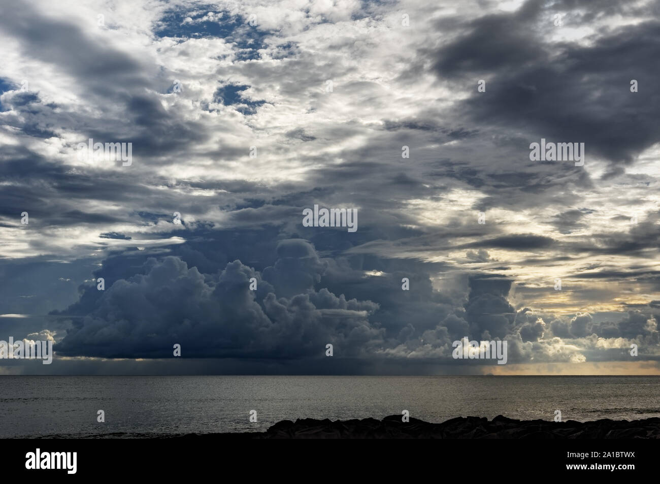 Vista da una spiaggia tropicale per una minacciosa grande nube scura formazione dal quale cade la pioggia - Location: Seychelles Foto Stock