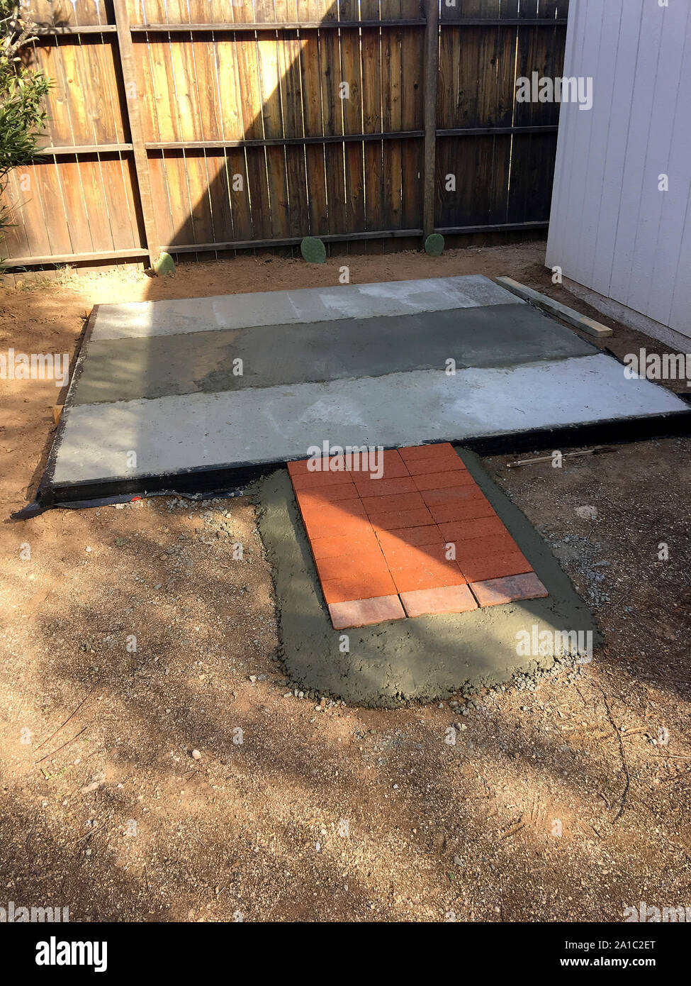 Essiccazione di cemento dopo essere stata versata in un asfalto quadro in legno per una base rialzata per un capannone Foto Stock