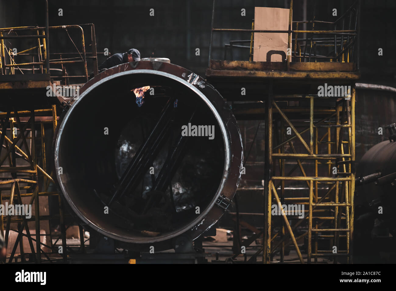 Lavoratore in una sporca e vecchia ma ancora funzionante di opere in metallo, vecchio stile, factory Foto Stock