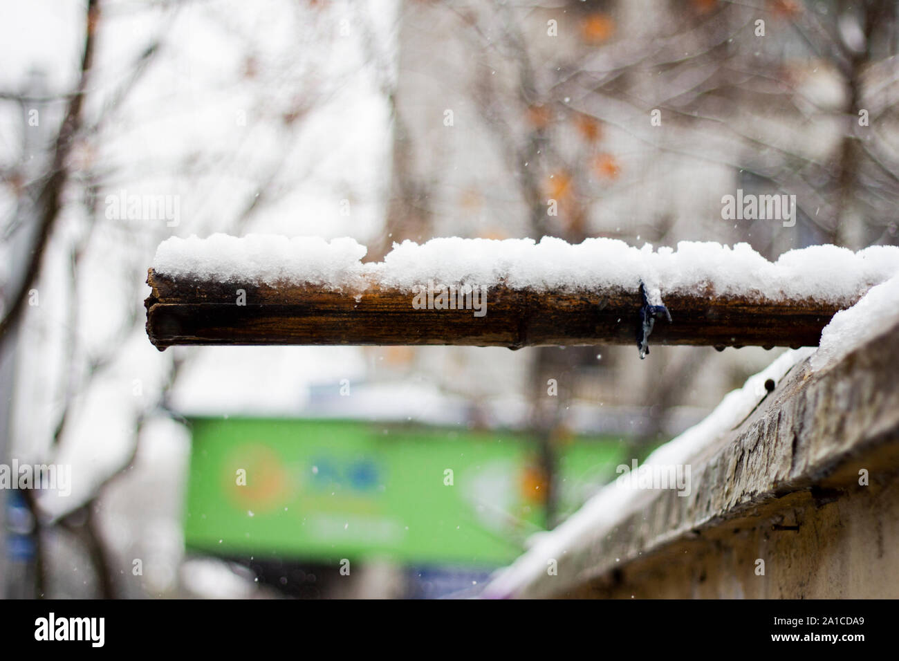 La fusione della neve off di un bastone di bambù che era posto sulla sommità di un negozio Foto Stock