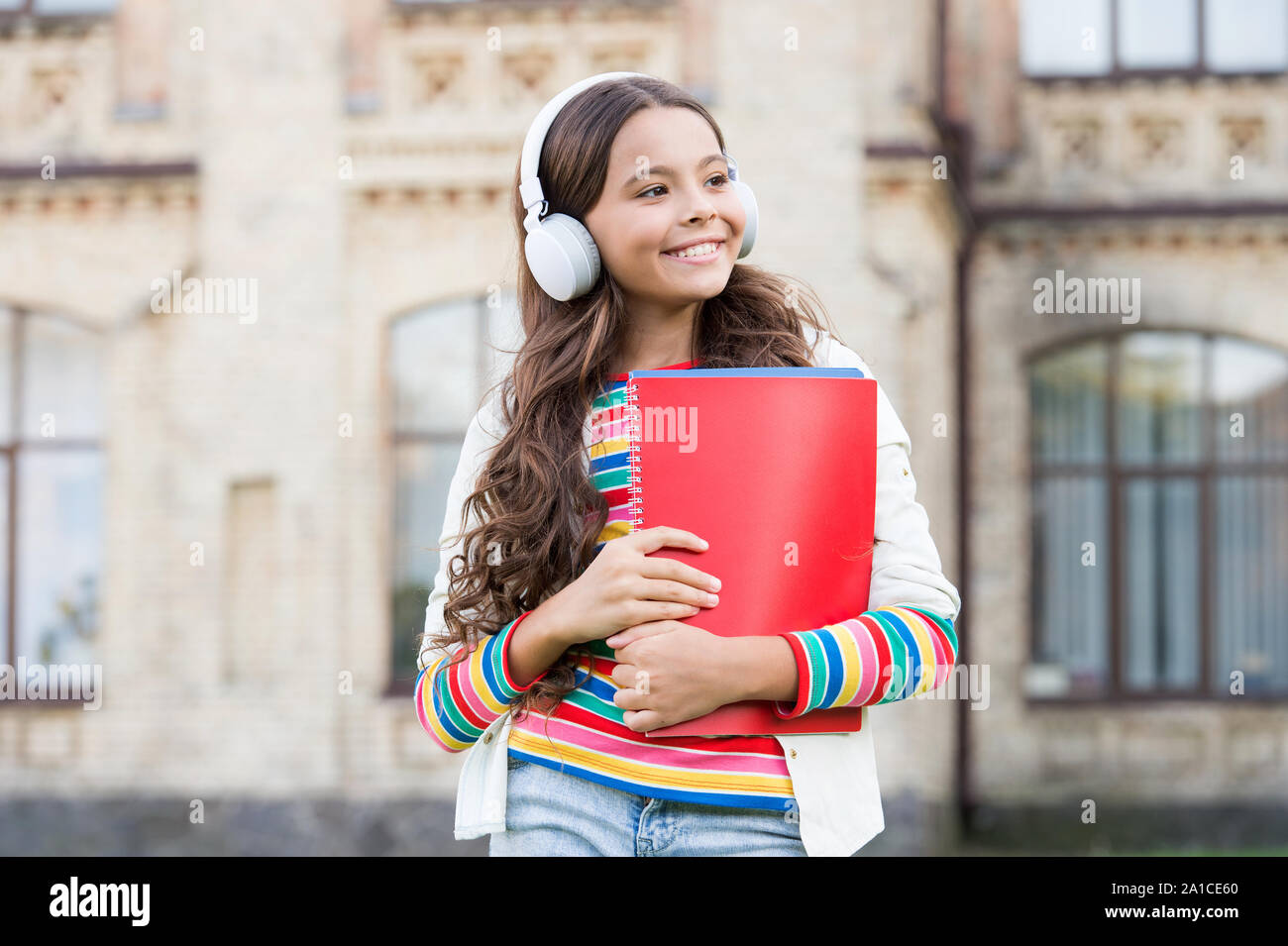 Si parla inglese. Bambino felice ascolto di audio inglese corso. Bambina di apprendimento della lingua inglese con audio libro. Migliorare il vostro inglese con lezioni audio. Foto Stock