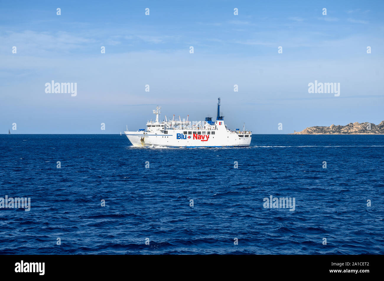 Bonifacio, Corsica-September, 2019. Traghetto Blu Navy vela in mare. Rocce dello sfondo Foto Stock