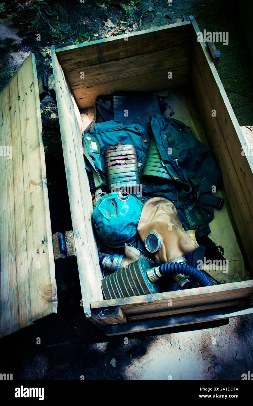 Cassa di legno con filtri arrugginito, maschera a gas e uniformi militari della Seconda Guerra Mondiale. Foto Stock
