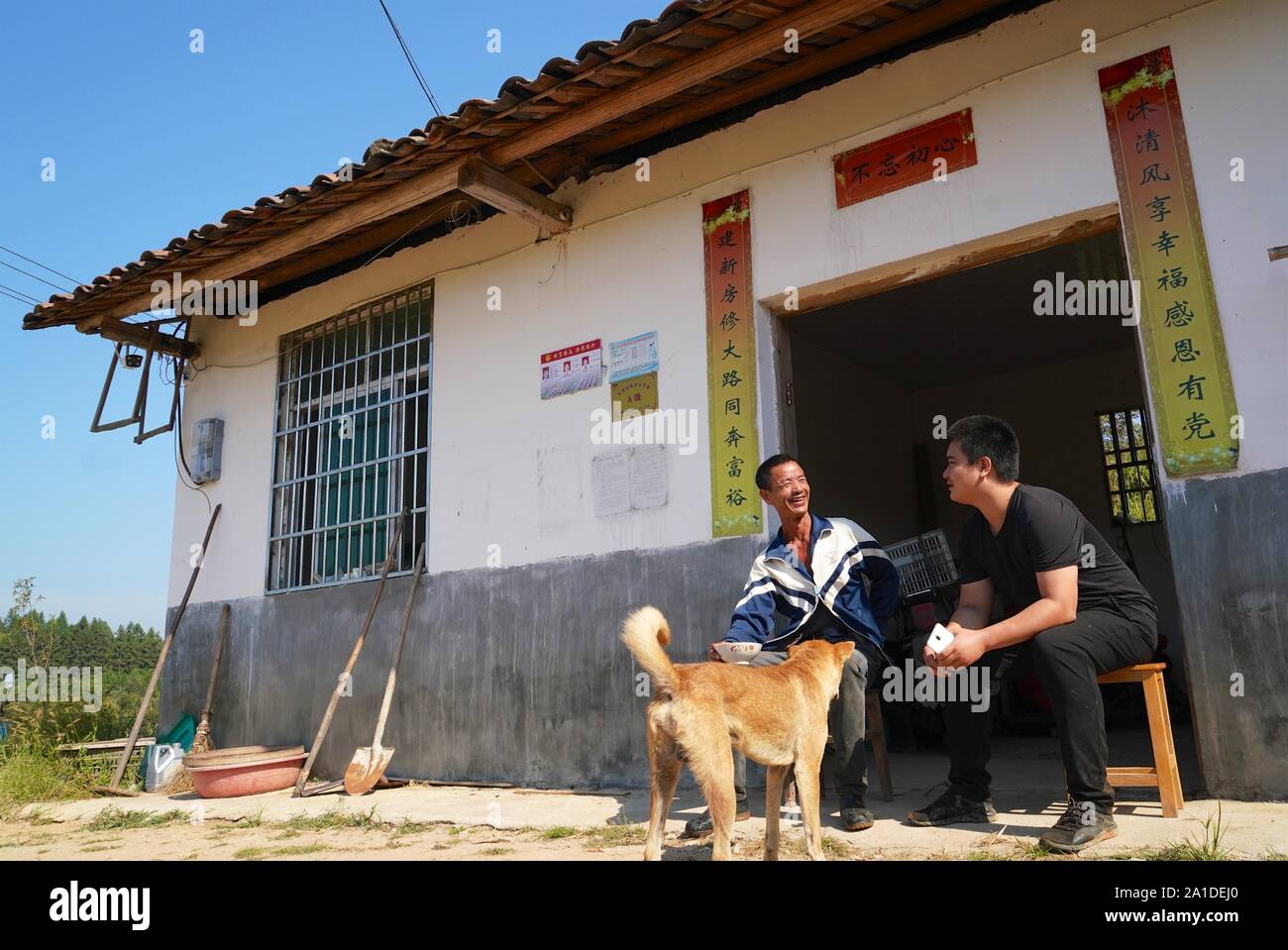 (190926) -- LICHUAN, Sett. 26, 2019 (Xinhua) -- Zhou Jing (R) Chat con suo padre di fronte alla sua casa nella contea di Lichuan, Cina orientale della provincia di Jiangxi, Sett. 25, 2019. Zhou Jing, 23, è un imprenditore e pittore. Dopo il diploma di scuola media nel 2012, Zhou ha scelto di studiare la pittura ad olio ad una industria creativa parco di Lichuan County. In aprile 2019, Zhou ha superato la prova e la valutazione del personale dell'industria creativa park e diventò ufficialmente un pittore. L'industria della pittura a olio in questa contea è ben sviluppata, come nel mese di agosto 2019, ci sono stati più di tremila persone da Lichuan contare Foto Stock