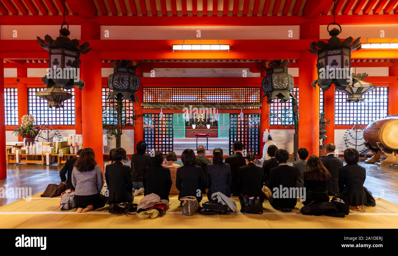 Buddisti pregano, santuario di Itsukushima, Miyajima, Baia di Hiroshima, Giappone Foto Stock
