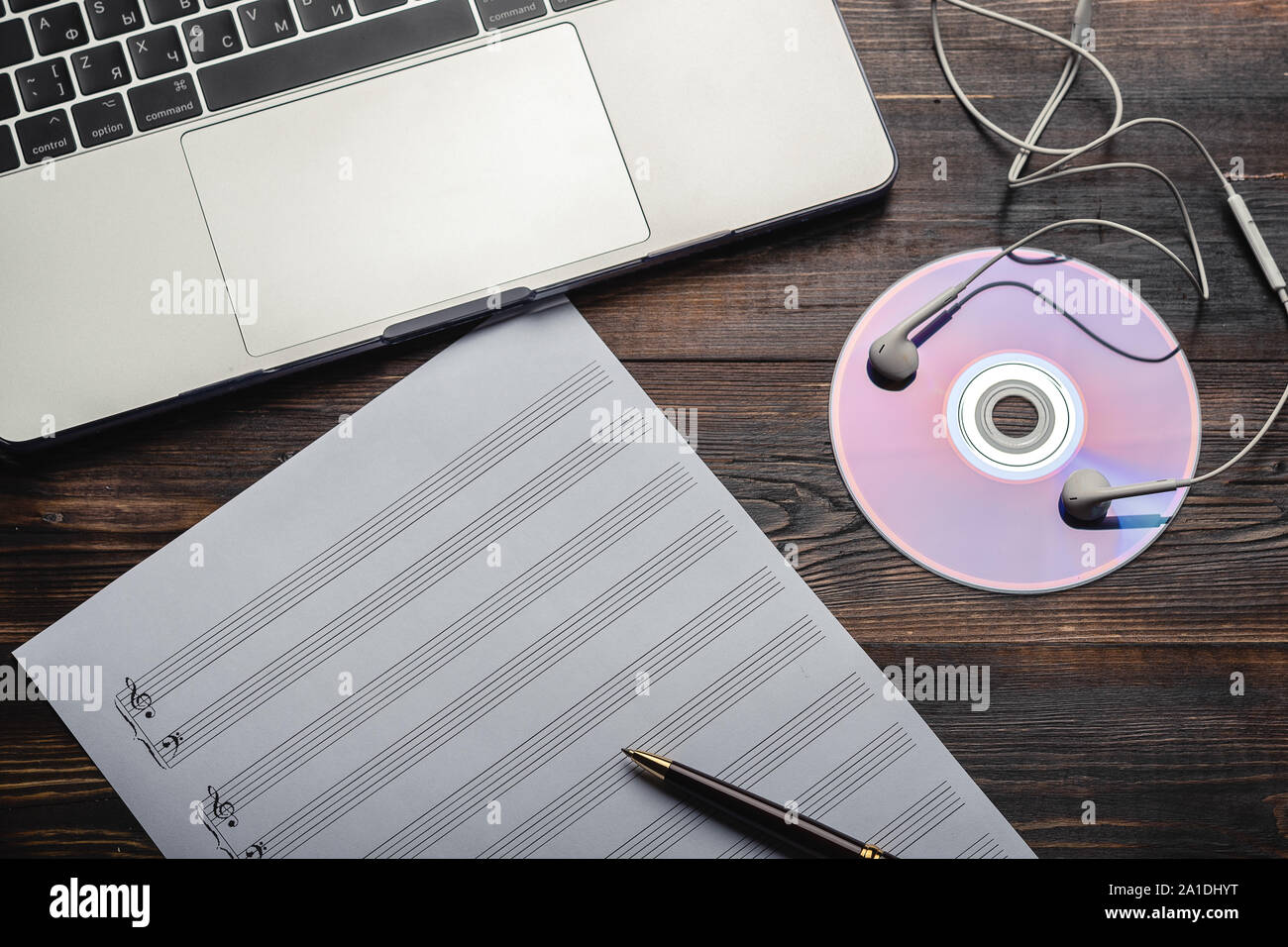 Computer portatile con cuffie, CD e carta da musica con penna su sfondo di legno. Copia dello spazio per il tuo testo. Vista dall'alto. Obsolete e di storage moderna Foto Stock