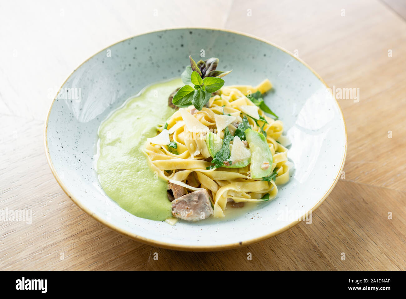 La pasta italiana Le tagliatelle con zucchine, Turchia e salsa verde. Formaggio parmigiano Foto Stock