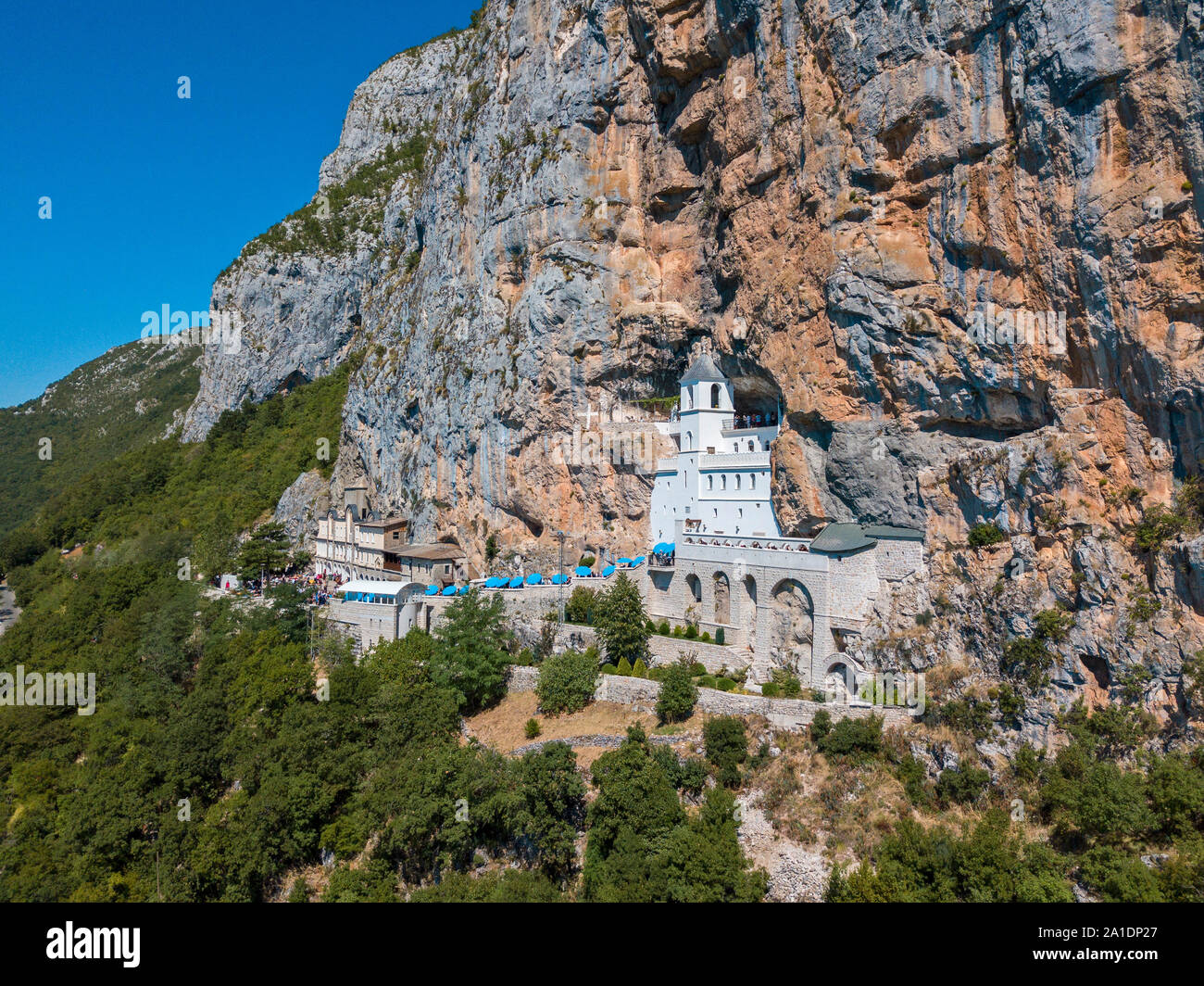 Vista aerea del monastero di Ostrog, Chiesa Ortodossa Serba situata contro una montagna verticale dello sfondo. Montenegro. Dedicata a San Basilio Foto Stock
