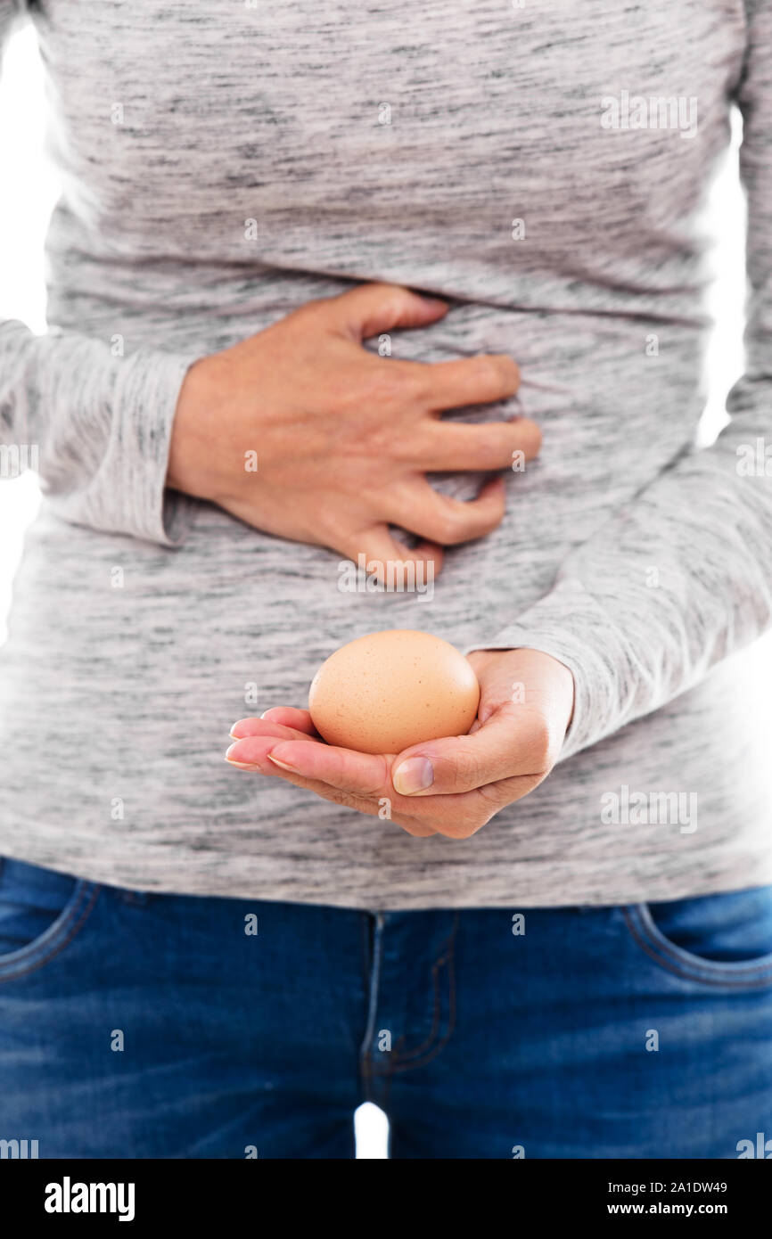 Donna con uovo allergia o un imbarazzo uovo è avere crampi dolorosi Foto Stock