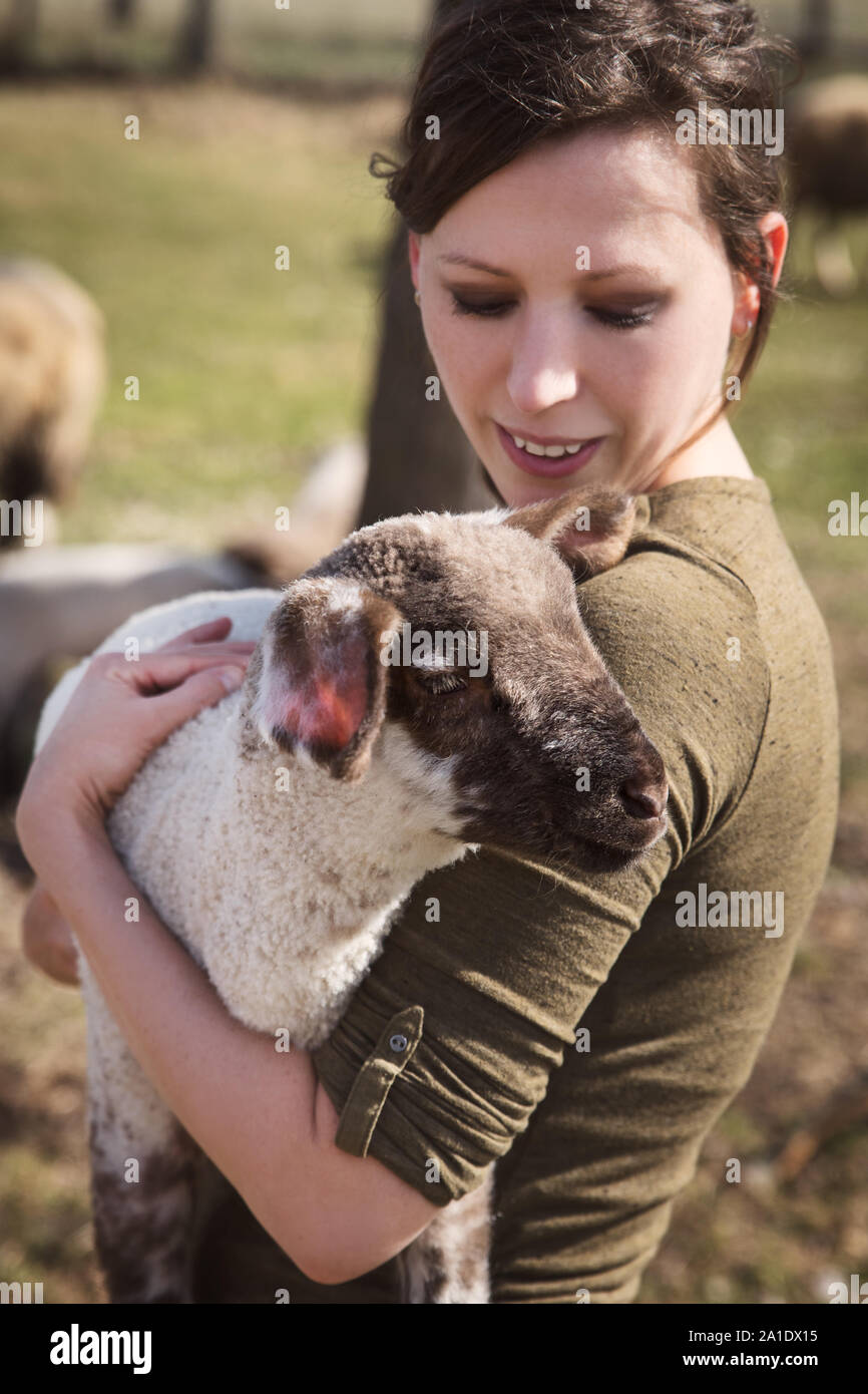 Donna che mantiene un agnello, concetto di animale-amare e protezione animale Foto Stock