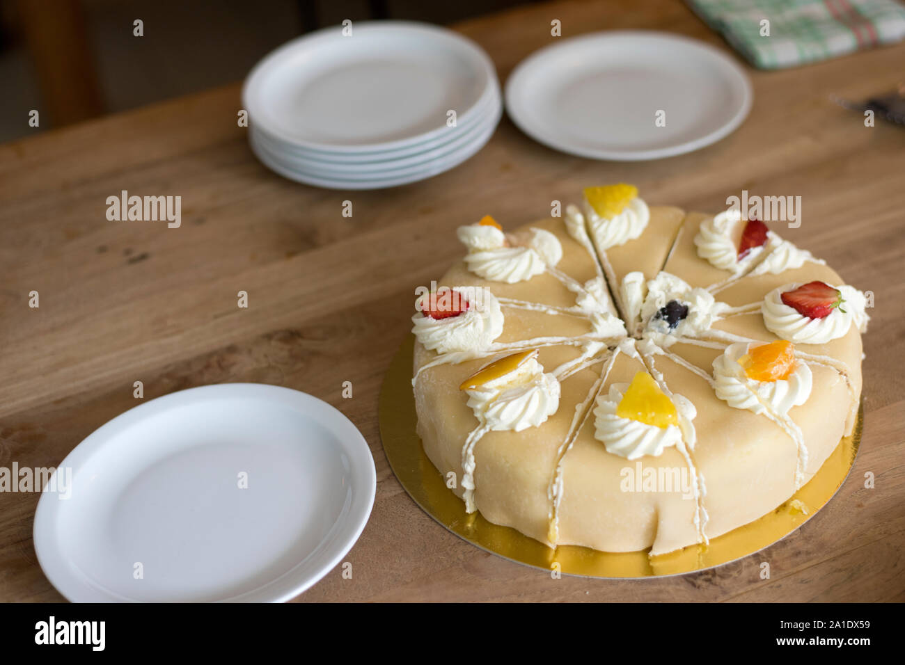 Torta bianca con panna glassa di crema e pezzi di frutta. Foto Stock