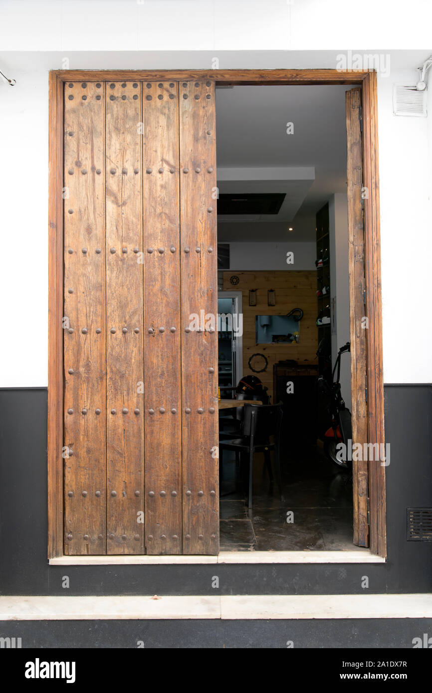 Siviglia, in Andalusia, Spagna - Foto di una porta in legno che conduce in una caffetteria/bar. Foto Stock