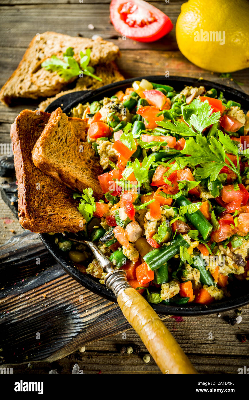 Messicana uovo Southwestern Scramble, semplice colazione sana idea con uova e verdure, con pane tostato. Sfondo di legno spazio copia Foto Stock