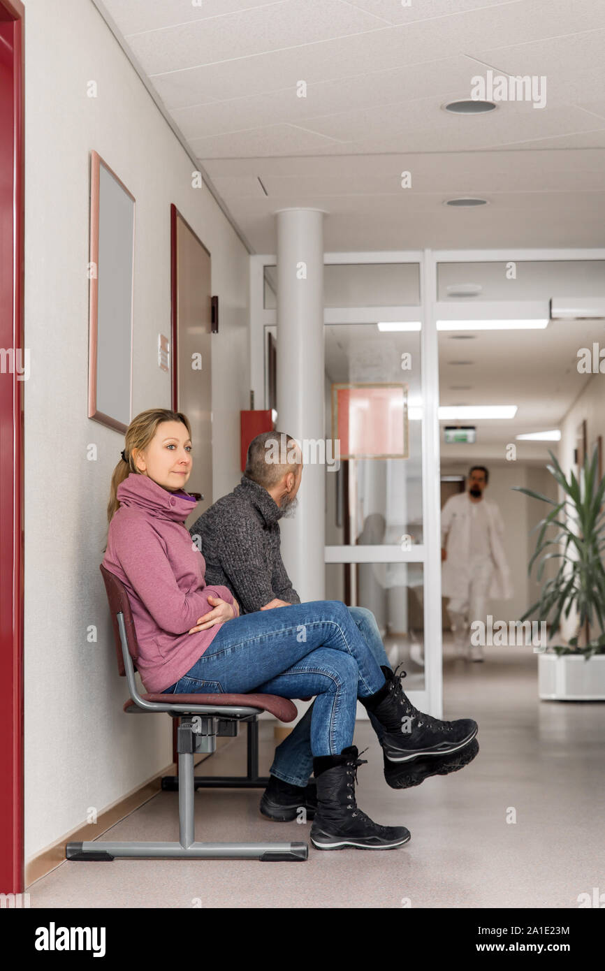 Medico e pazienti in una sala di attesa o stanza di emergenza Foto Stock