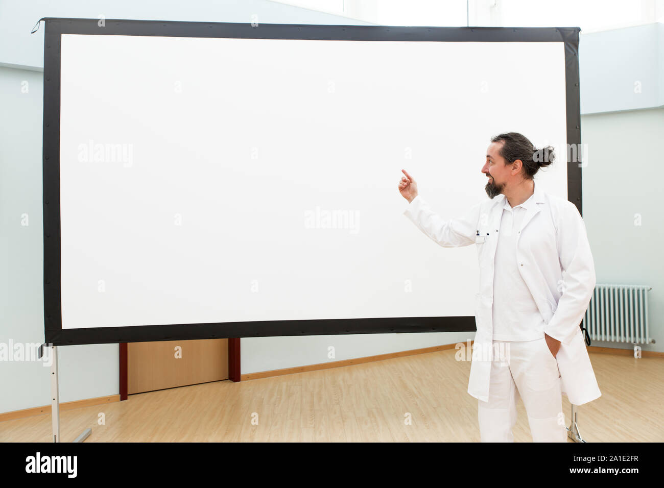 Medico è in piedi di fronte a una lavagna vuota dando una lezione o briefing Foto Stock