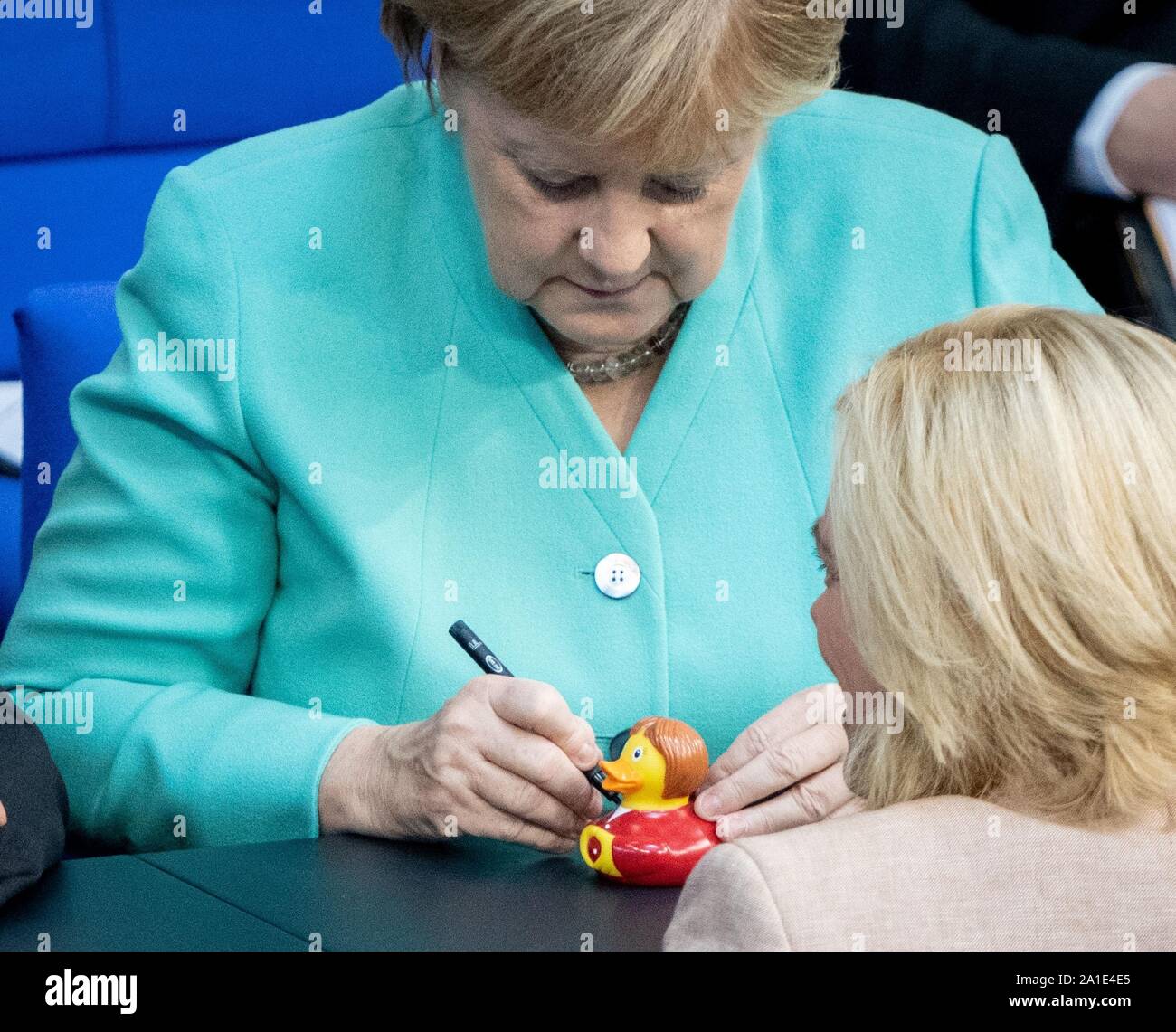 Berlino, Germania. 26 Sep, 2019. Corregge il nome del fotografo - Cancelliere Angela Merkel (CDU) scrive su un anatra squeaker per Julia Klöckner (r, CDU), Ministro federale dell'Agricoltura e dell'alimentazione, alla 115a sessione del Bundestag. L'oggetto del dibattito è anche la protezione del clima 2030". Credito: Kay Nietfeld/dpa/Alamy Live News Foto Stock