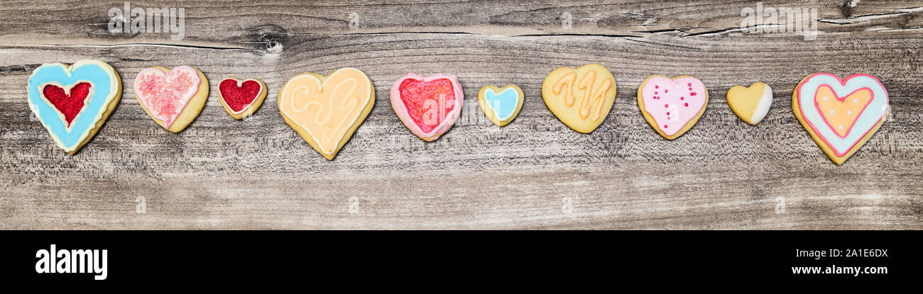La testata e colorati di cuore i cookie in una linea, un concetto per la festa della mamma o il giorno di San Valentino Foto Stock