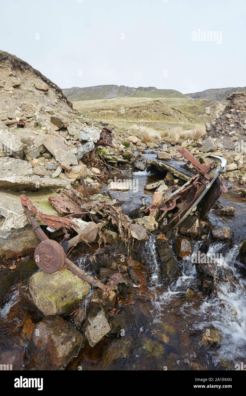 Abbandonati i resti di un veicolo e rottami di metallo in un ruscello vicino alle vecchie miniere di piombo sulla strada Oxclose, Ivy cicatrice, tra Woodhall e a Carperby, Yorkshire Foto Stock