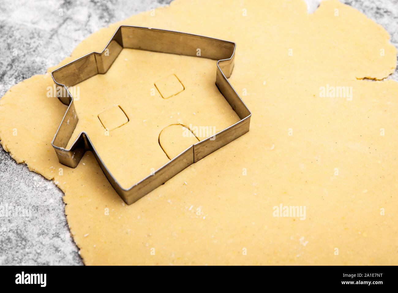 Pasta cruda e cookie cutter con casa forma, concetto la cottura di un motorino di avviamento home, copyspace Foto Stock