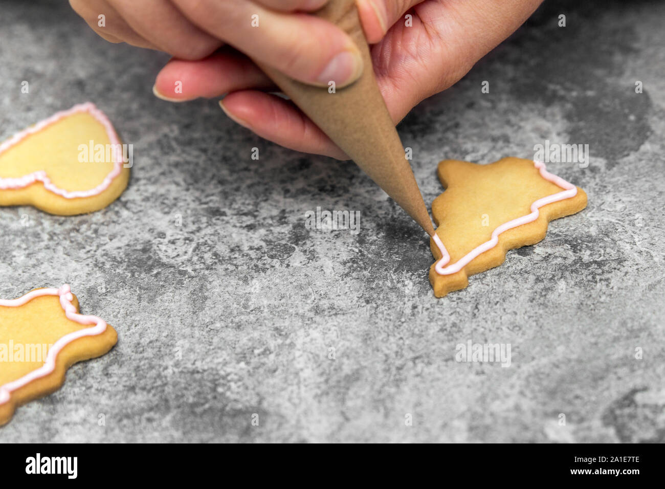 Lo zucchero baker la decorazione luminosa i biscotti con la glassa reale o glassa, concetto fabbricazione e area di lavoro Foto Stock